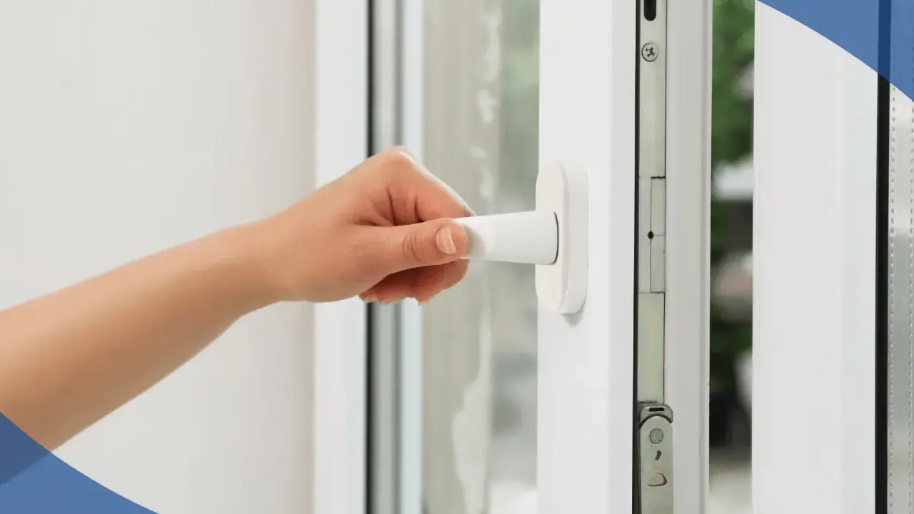 Mano girando la manija de unas ventanas de seguridad para casas, mostrando el mecanismo interno.